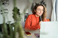 Online learning concept. Young smiling pretty woman student using laptop elearning or remote working at home office using laptop computer