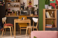 Student apartment kitchen and dining area showing backpack, mugs, and study break setup, representing independent living and campus lifestyle.
